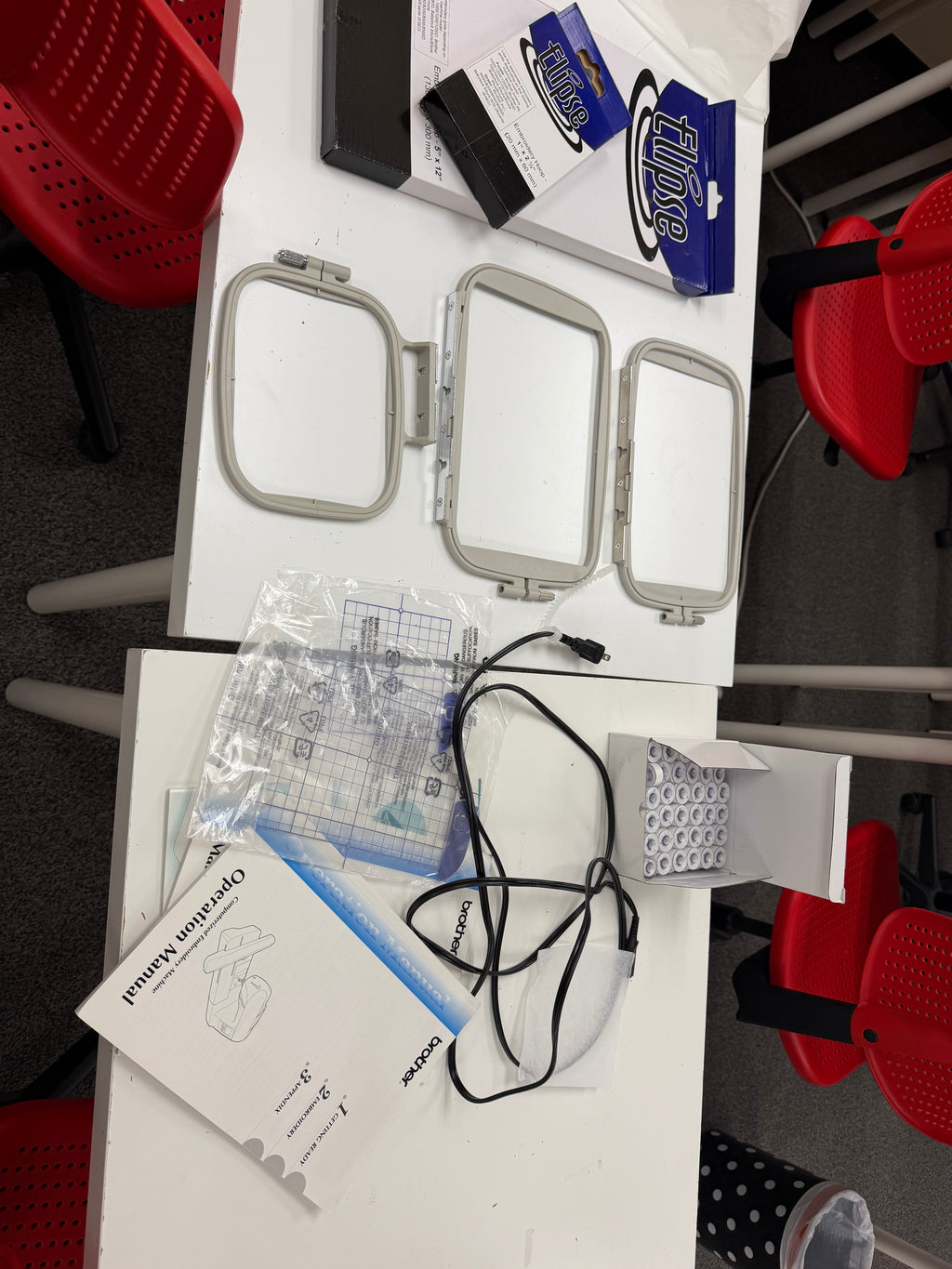 Brother PE770 included accessories: three embroidery hoops, Ellipse 5x12 and 1x2.5 hoops, grid sheets, bobbins, power cord and operation manual